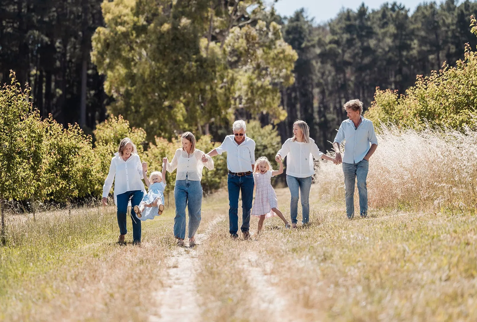 blackwood forest family photography 82 Family enjoying a joyful walk in a sunny, green park together.