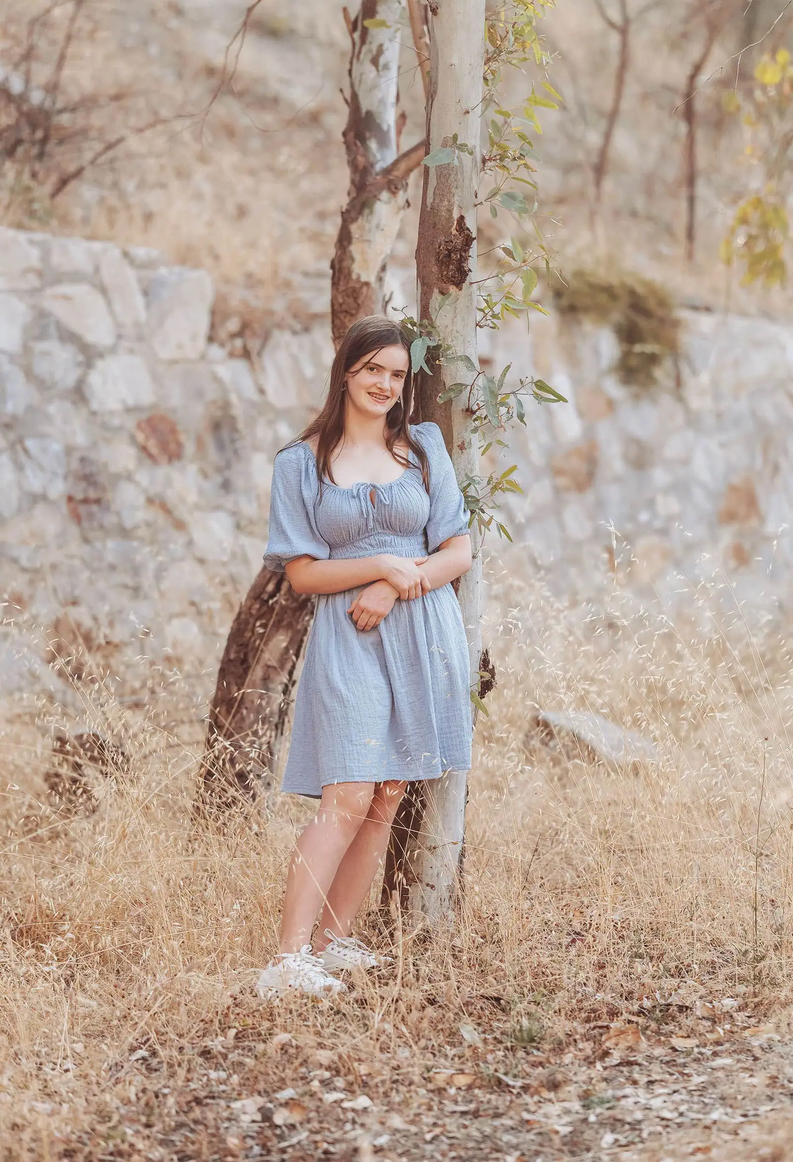 beautiful anstey hill family photoshoot 13 Young woman in blue dress by a tree, serene outdoor scene with natural sunlight.