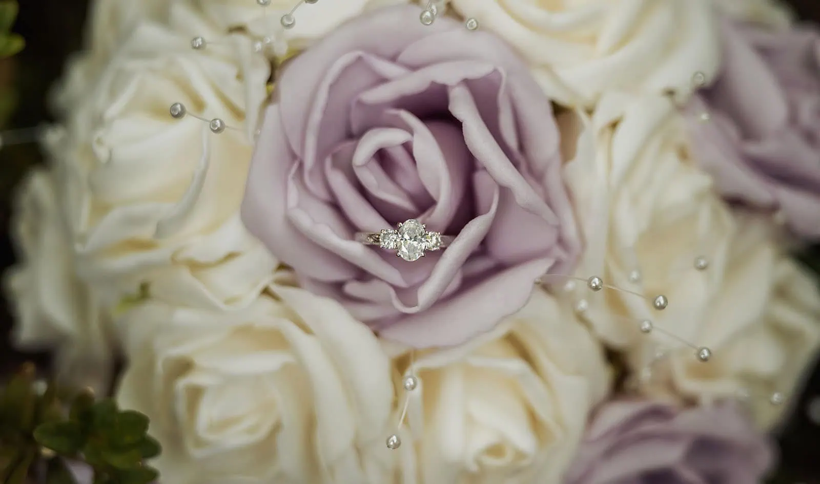 engagement rings under $2,000: 7 designs that don't look cheap 3 Engagement ring nestled in a lavender rose surrounded by white roses and delicate accents.