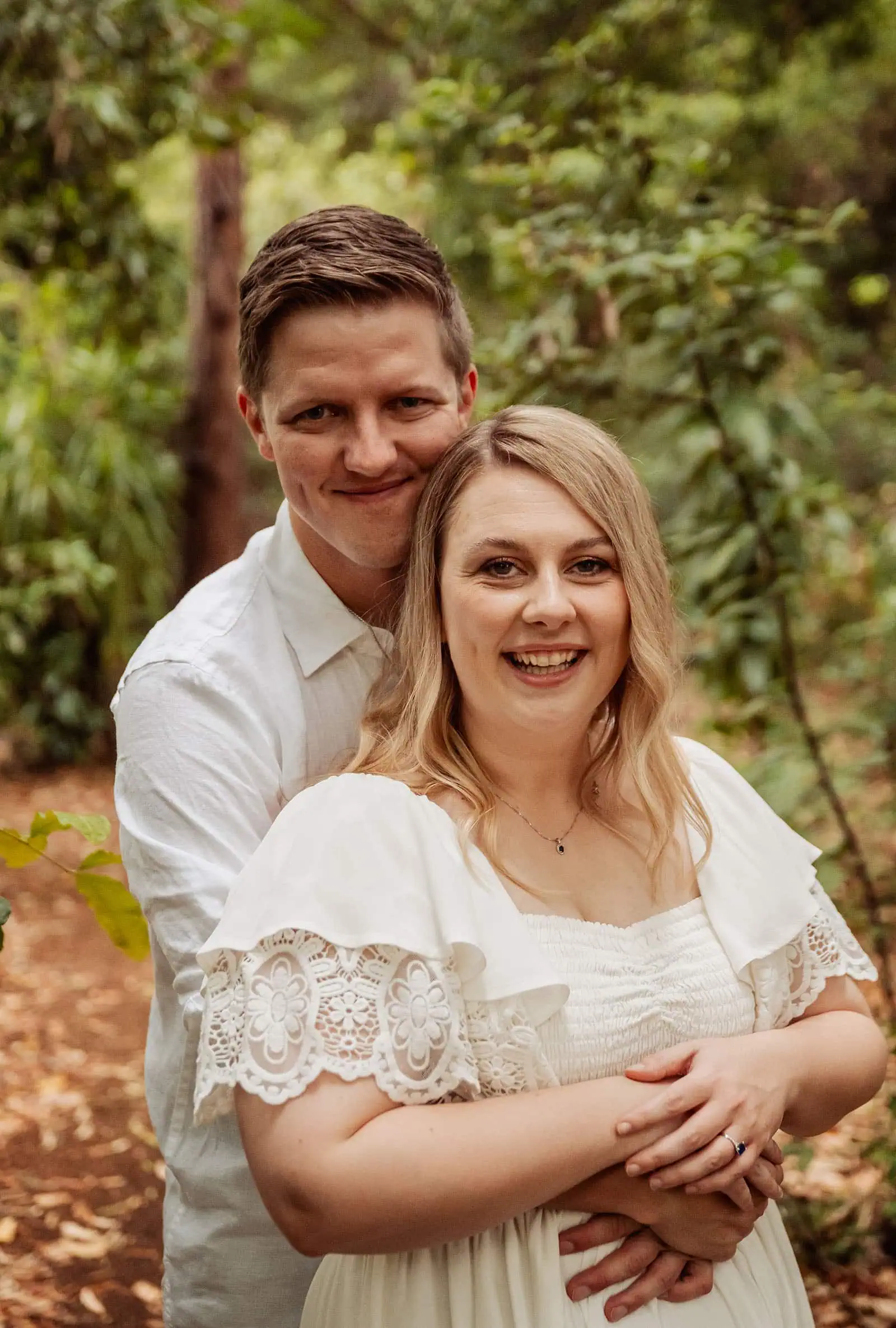 botanic gardens wedding shoot - olivia & sean 25 Couple embracing in sunlit, lush greenery, conveying love and tranquility outdoors.