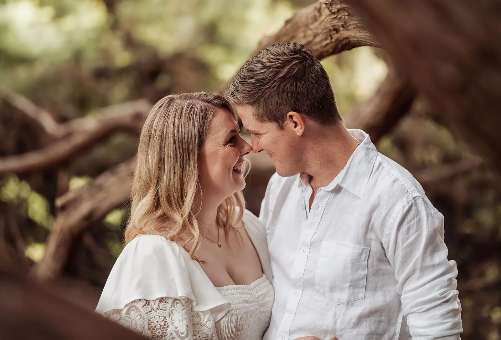 botanic gardens wedding shoot - olivia & sean 23 Couple shares a loving moment in a lush forest, capturing romance and natures tranquility.