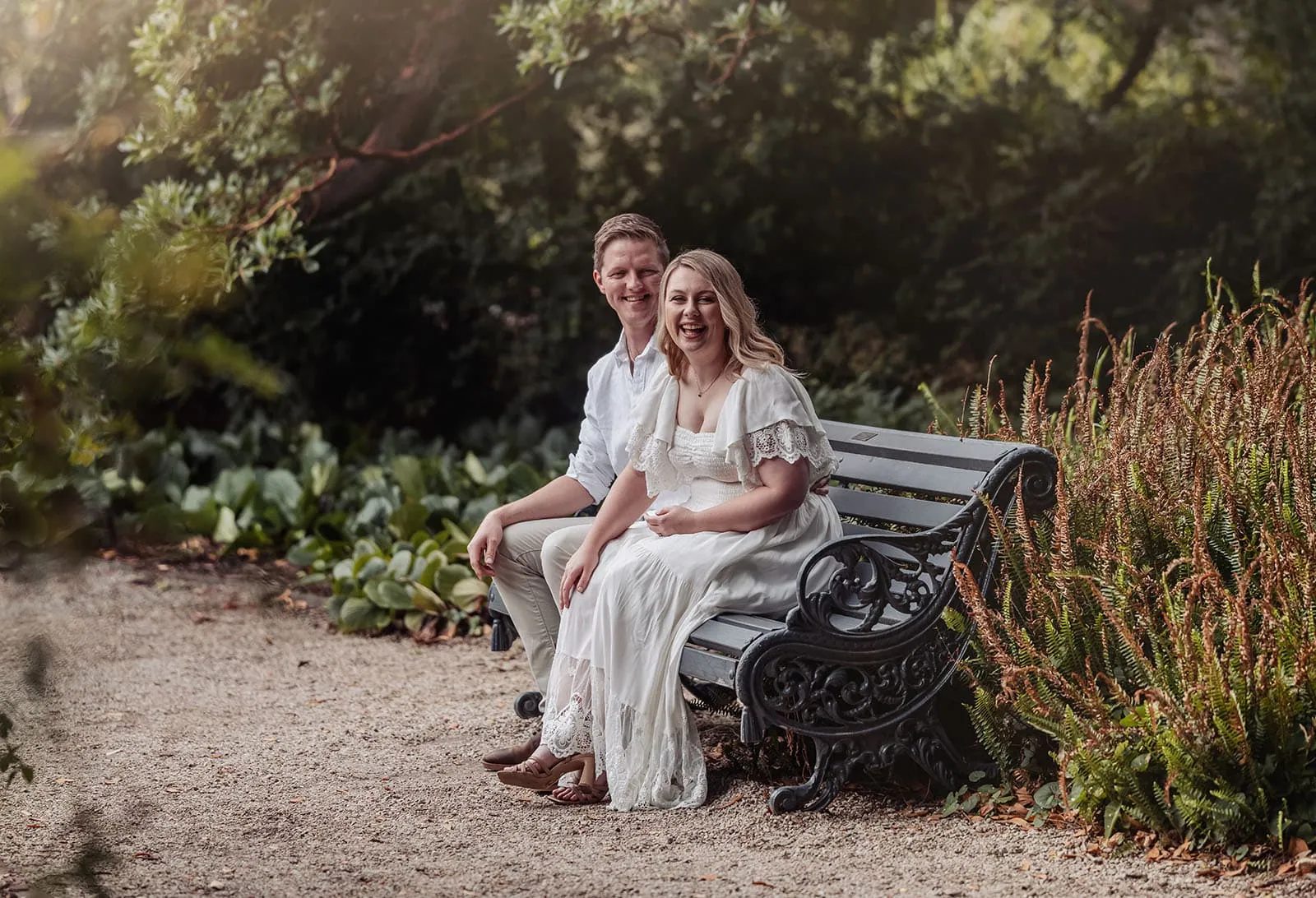 botanic gardens wedding shoot - olivia & sean 5 Romantic couple on a bench amidst lush greenery in a serene garden setting.