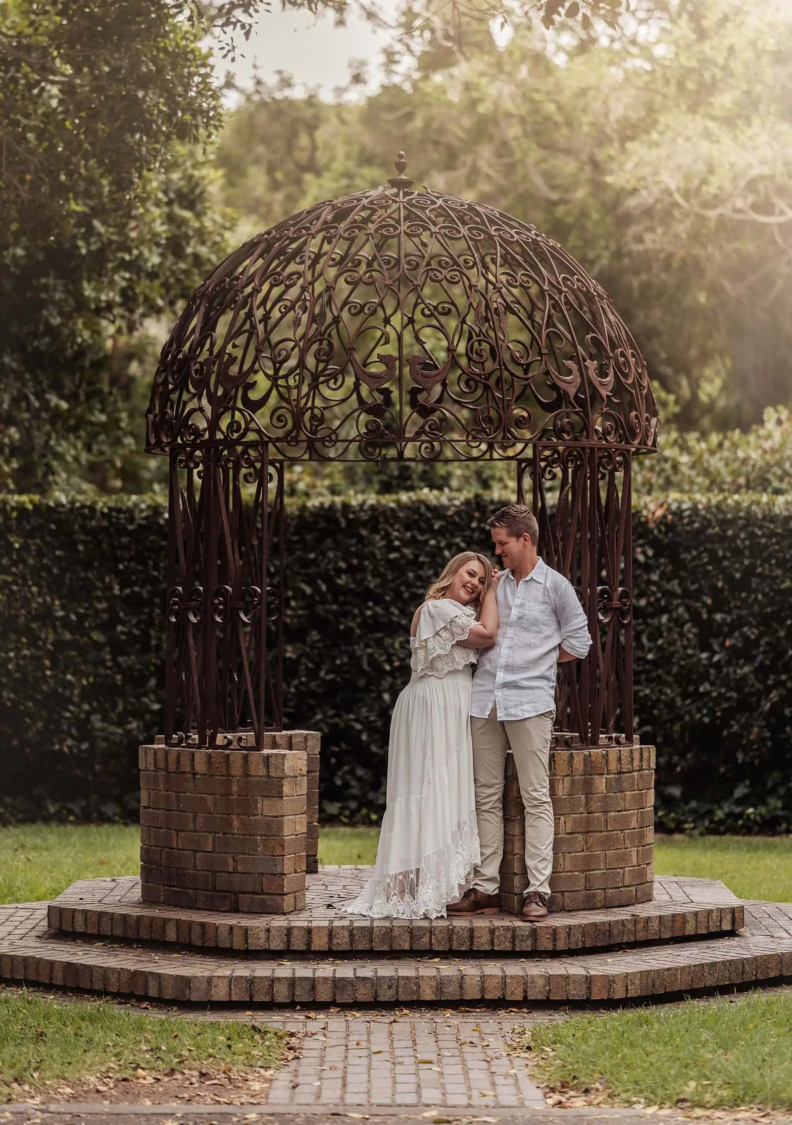 botanic gardens wedding shoot - olivia & sean 13 Romantic couple in gazebo surrounded by lush garden, embracing love under ornate dome.