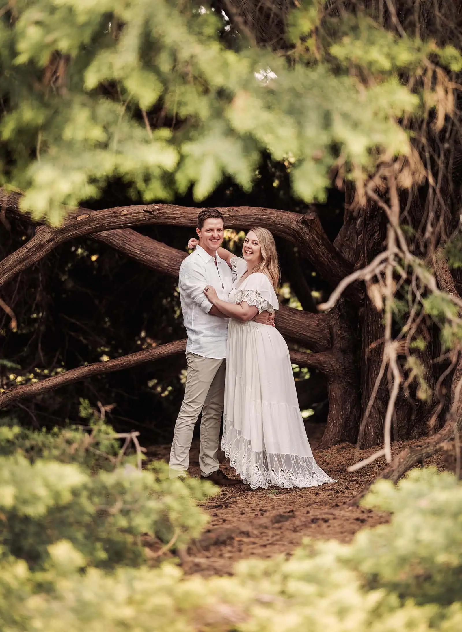 botanic gardens wedding shoot - olivia & sean 22 Romantic couple embracing in nature under green canopy, exuding happiness and tranquility.