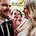 Bride and groom celebrate their wedding, joined by a playful photobomber in a garden setting.