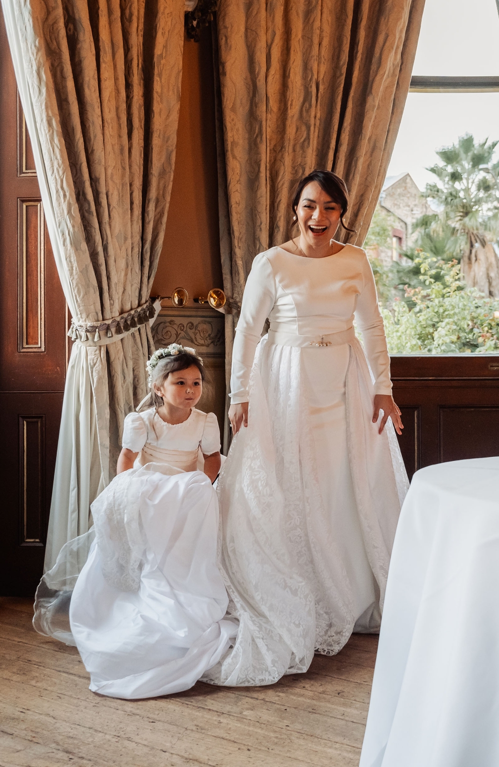 adelaide's st peter's cathedral wedding - irish & nick 40 Bride and flower girl in white wedding dresses by a sunlit window.