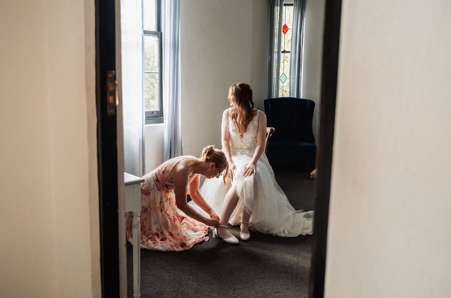 beautiful manor basket range wedding - sophie & theodore 93 Bride preparing, assisted by friend in serene, softly lit room.