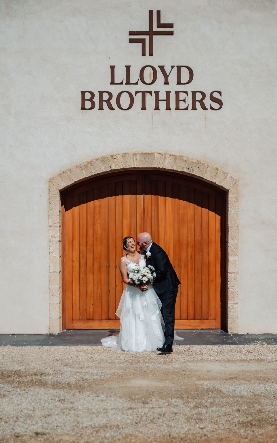 lloyd brothers wedding - dajana & tom 26 Newlywed couple at Lloyd Brothers venue, elegant rustic setting, sunny, joyful moment.