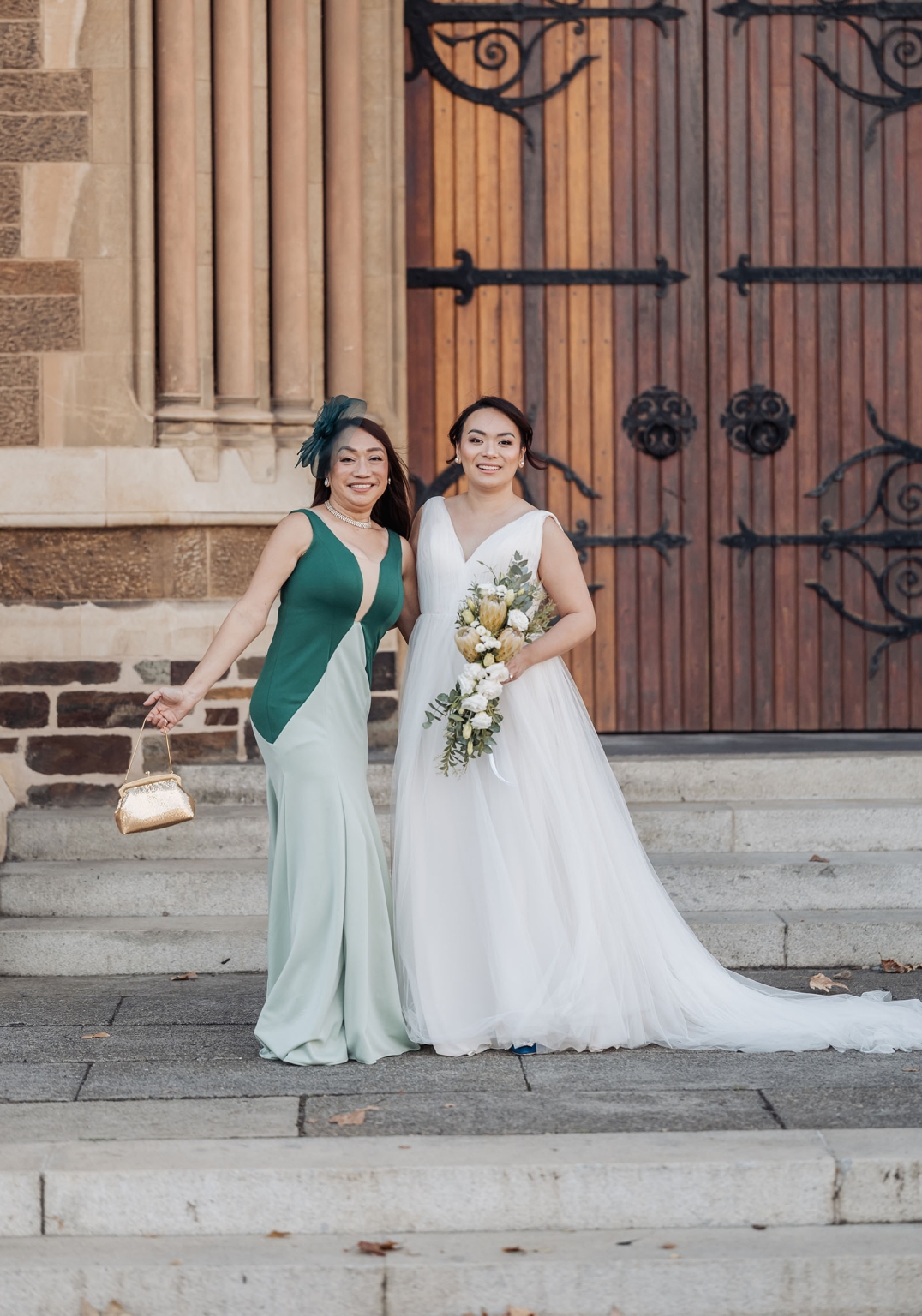 adelaide's st peter's cathedral wedding - irish & nick 4 Bride with wedding guest on historic church steps.