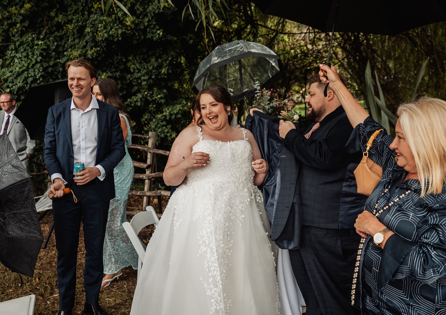 comida wedding - georgia & james 23 Joyful wedding celebration with bride laughing, surrounded by guests in elegant outdoor setting.