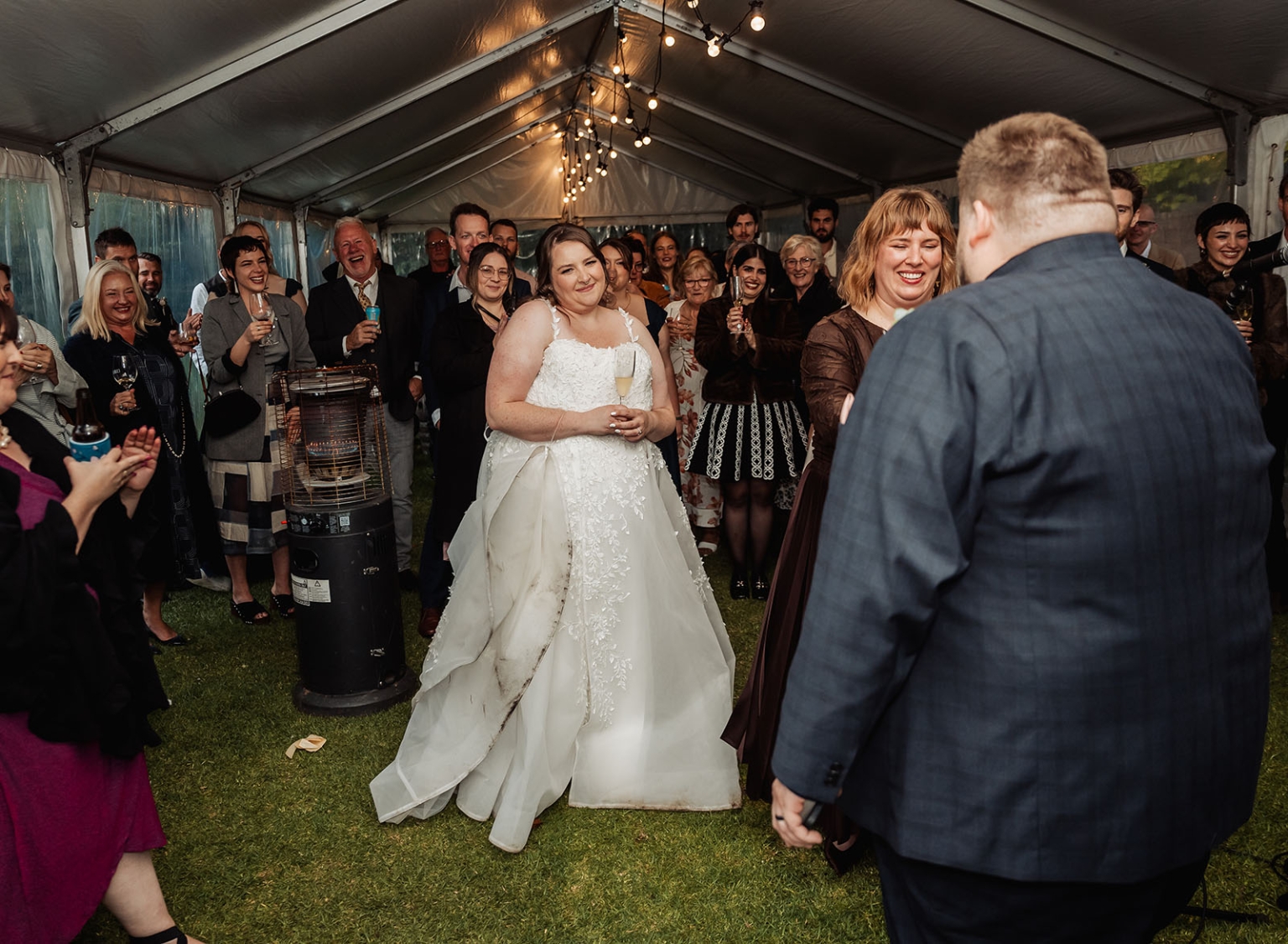 comida wedding - georgia & james 47 Joyful wedding reception with bride, groom, and guests celebrating under illuminated tent.