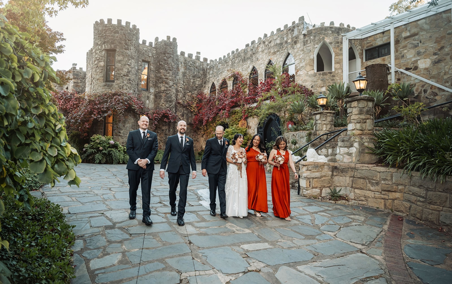 adelaide hills wedding at the manor - jo & dan 42 Castle wedding party walking through romantic stone courtyard.