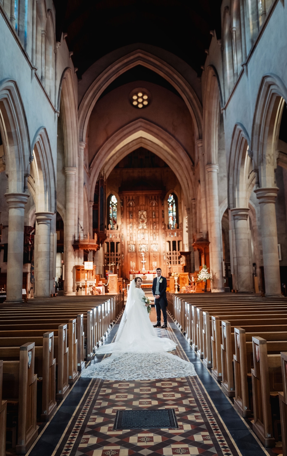 adelaide's st peter's cathedral wedding - irish & nick 38 Cathedral wedding portrait of bride and groom in aisle with lace train.