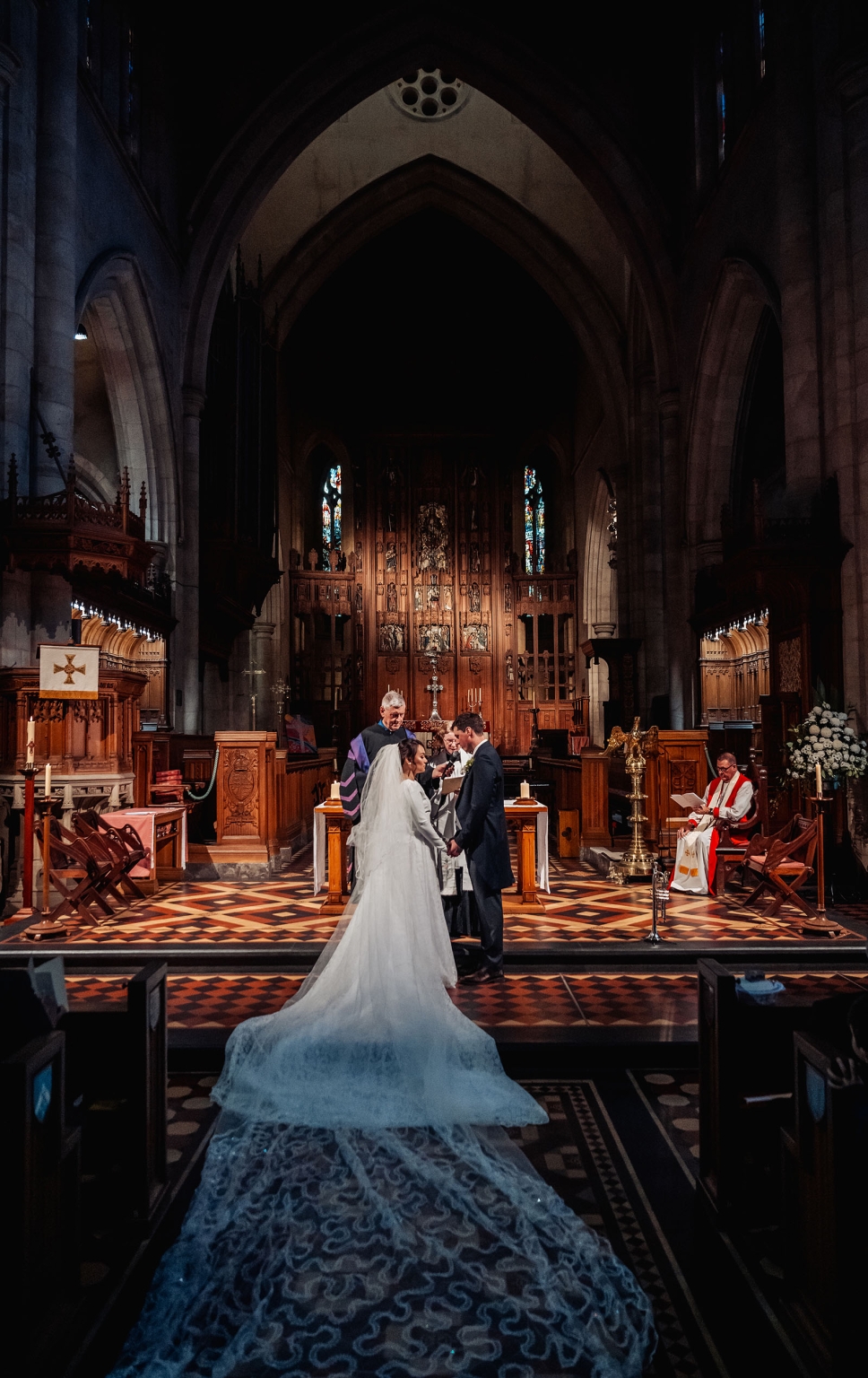 adelaide's st peter's cathedral wedding - irish & nick 22 Cathedral wedding ceremony with bride, groom, and long lace train in Gothic church.