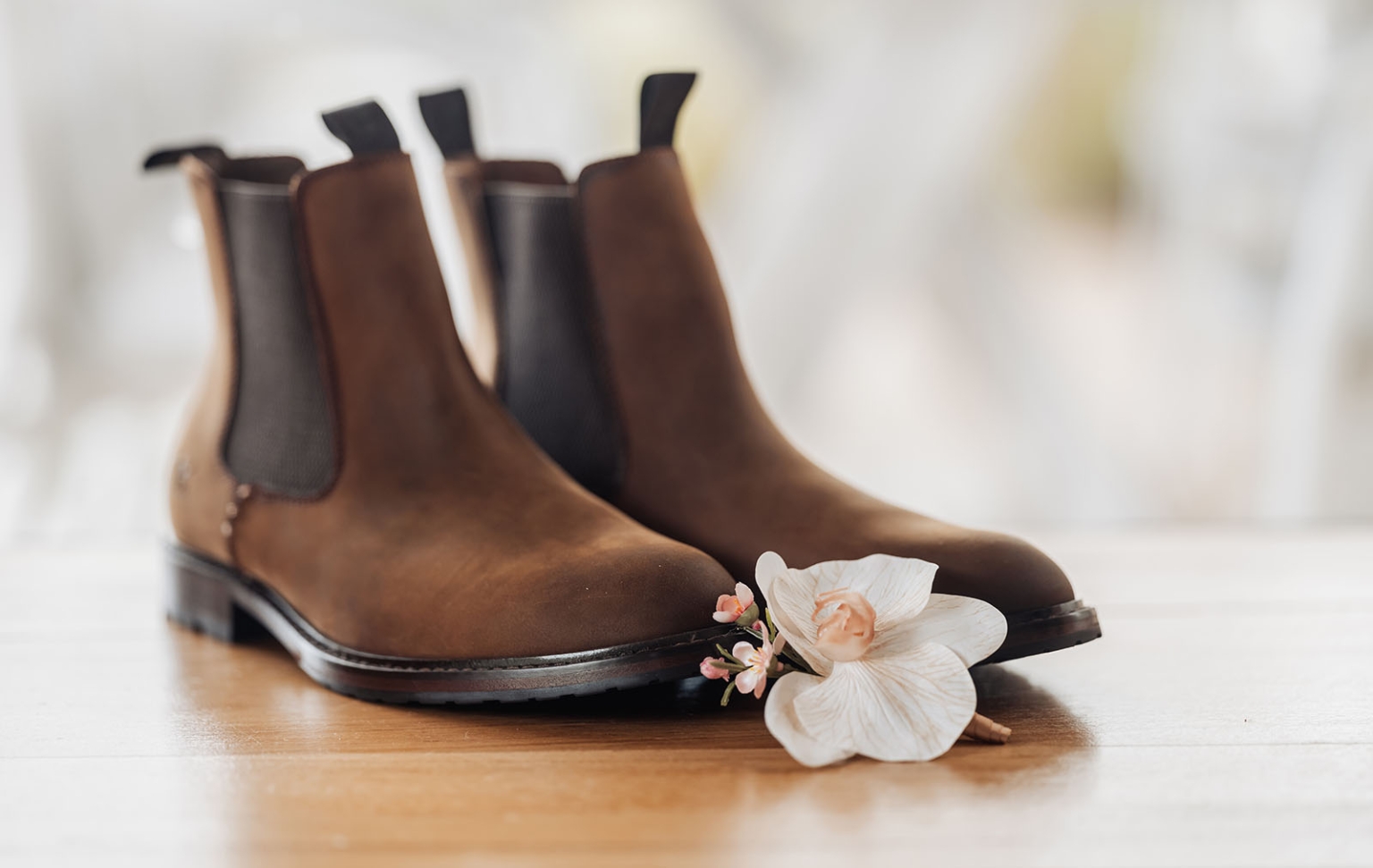 the lane vineyard wedding - caitlyn & craig 64 Elegant brown leather Chelsea boots with delicate white orchid and pink blossoms.
