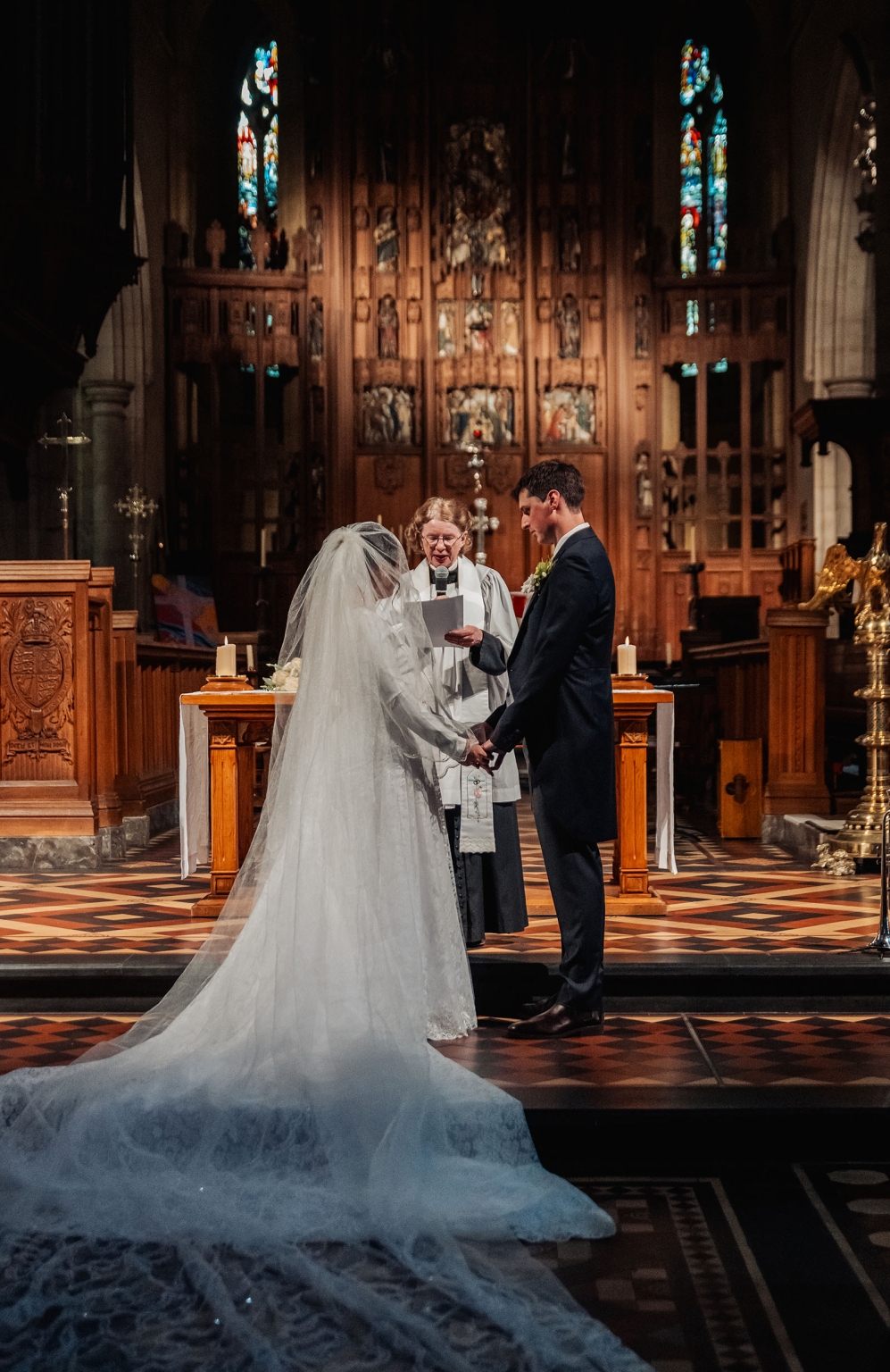 adelaide's st peter's cathedral wedding - irish & nick 21 Bride and groom exchange vows during a church wedding ceremony.