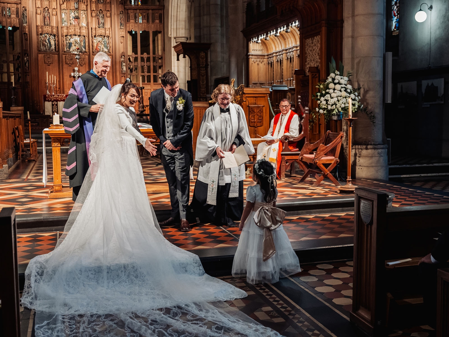 adelaide's st peter's cathedral wedding - irish & nick 23 Flower girl charms bride and groom during joyful church wedding ceremony.