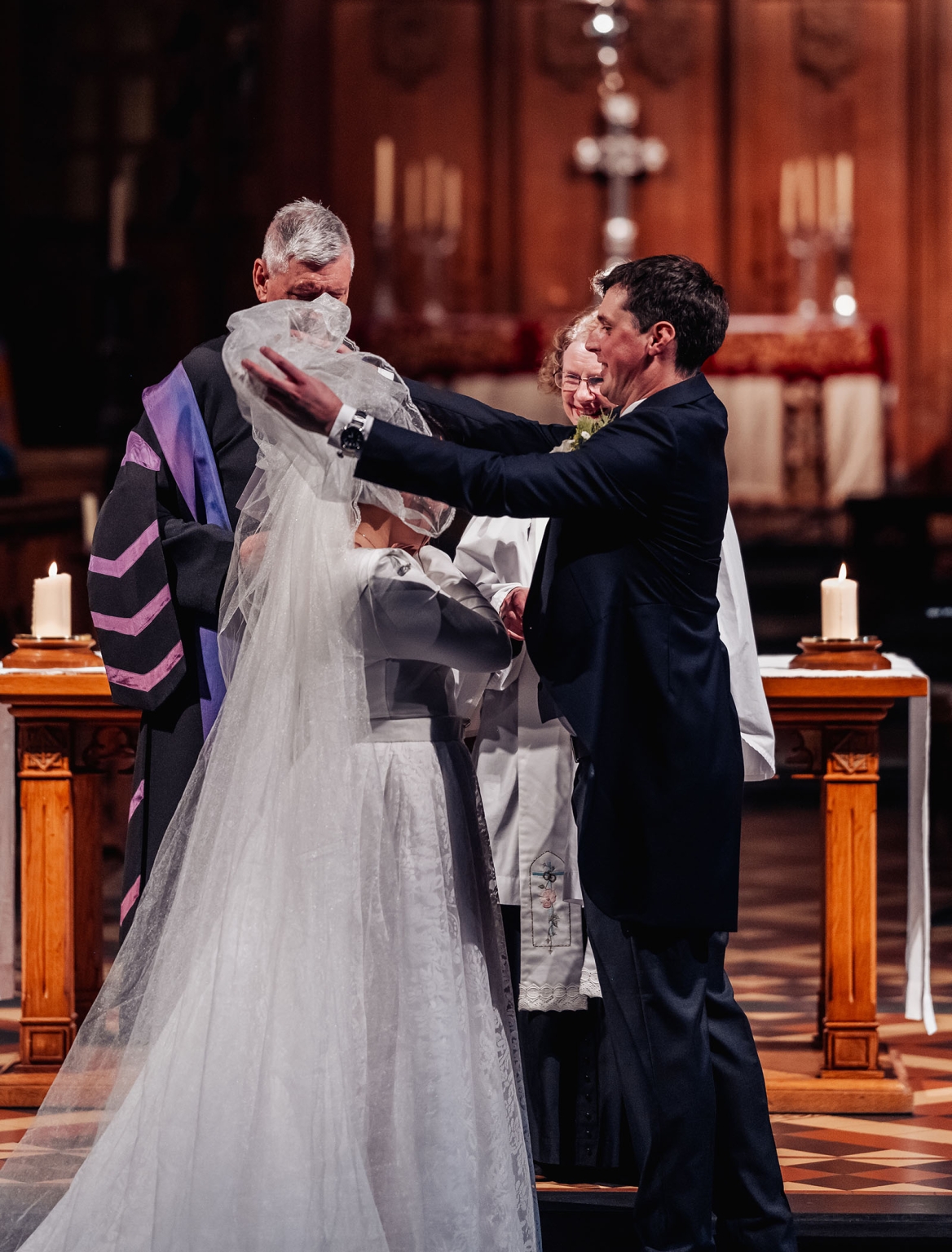 adelaide's st peter's cathedral wedding - irish & nick 20 Groom lifts bride’s veil during intimate church wedding ceremony.