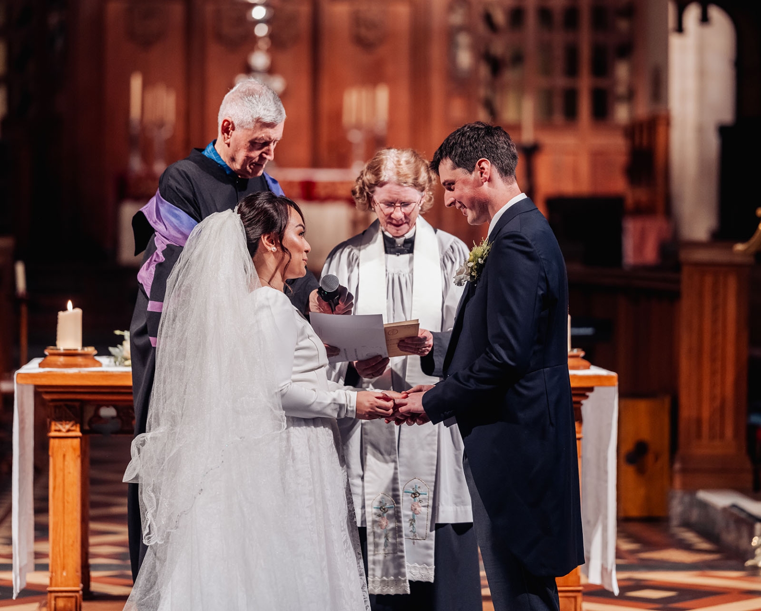 adelaide's st peter's cathedral wedding - irish & nick 24 Bride and groom exchange wedding vows in a warmly lit church ceremony.