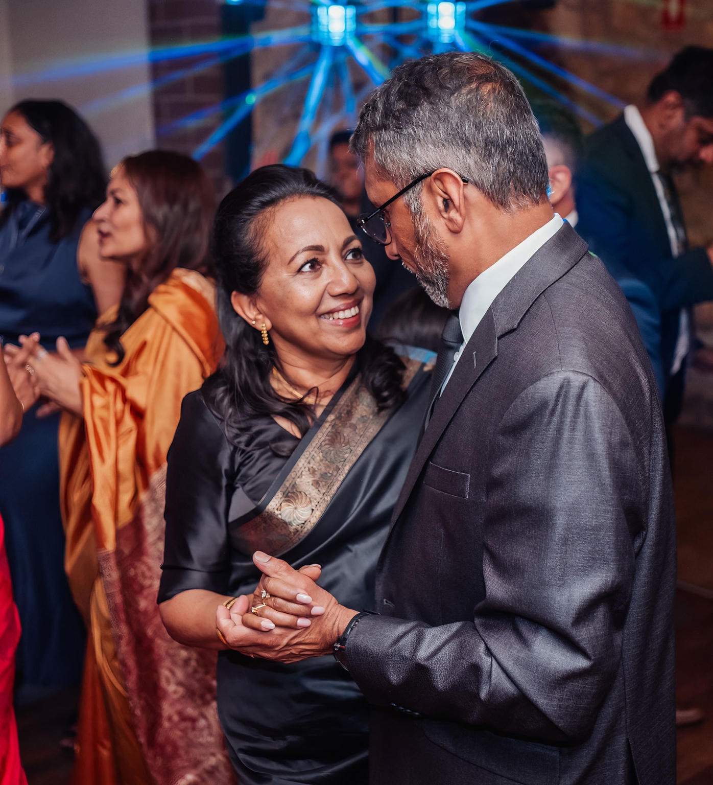 manor wedding in basket range - methmini & aravinda 173 Couple dancing joyfully at formal event, wearing elegant attire and showcasing cultural richness.