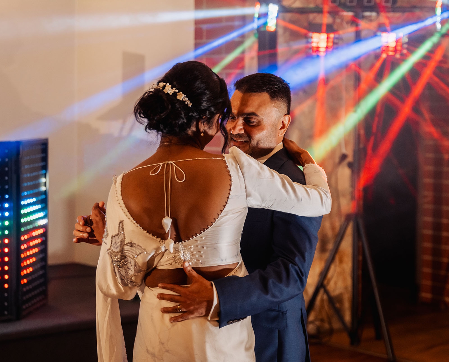 manor wedding in basket range - methmini & aravinda 168 Couple joyfully dancing at wedding with elegant attire, festive lights, and intimate connection.