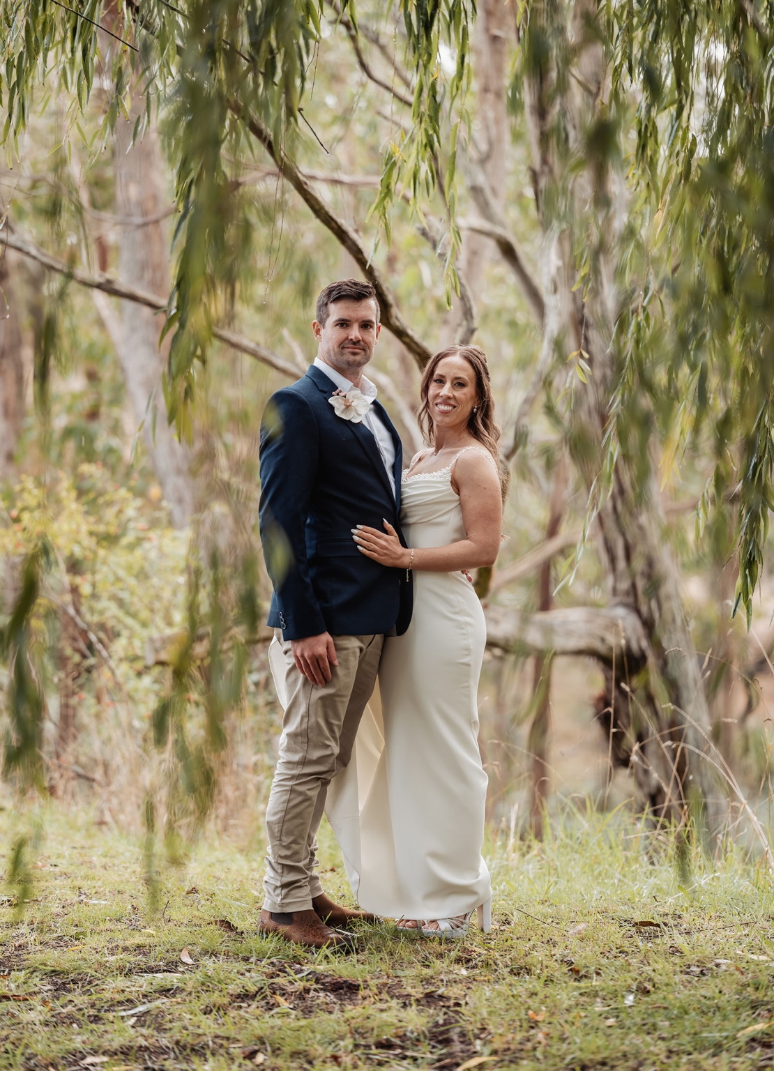 the lane vineyard wedding - caitlyn & craig 105 Elegant couple in wedding attire amidst lush greenery and tranquil forest.