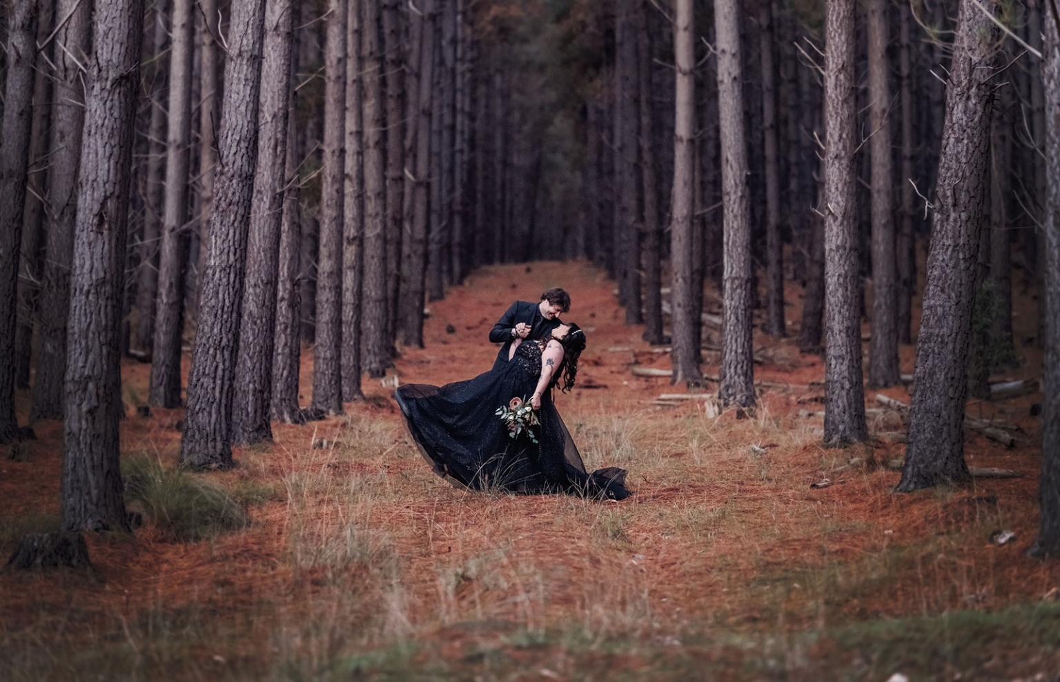 kuitpo forest metal themed wedding – erin & michael 24 Gothic wedding couple dancing in a pine forest with black gown and bouquet.