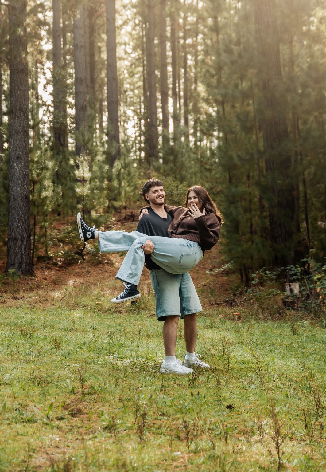 cabn at kuitpo forest proposal - tamsyn & blake 25 Loving couple enjoying a playful, romantic moment in a sunlit forest setting.