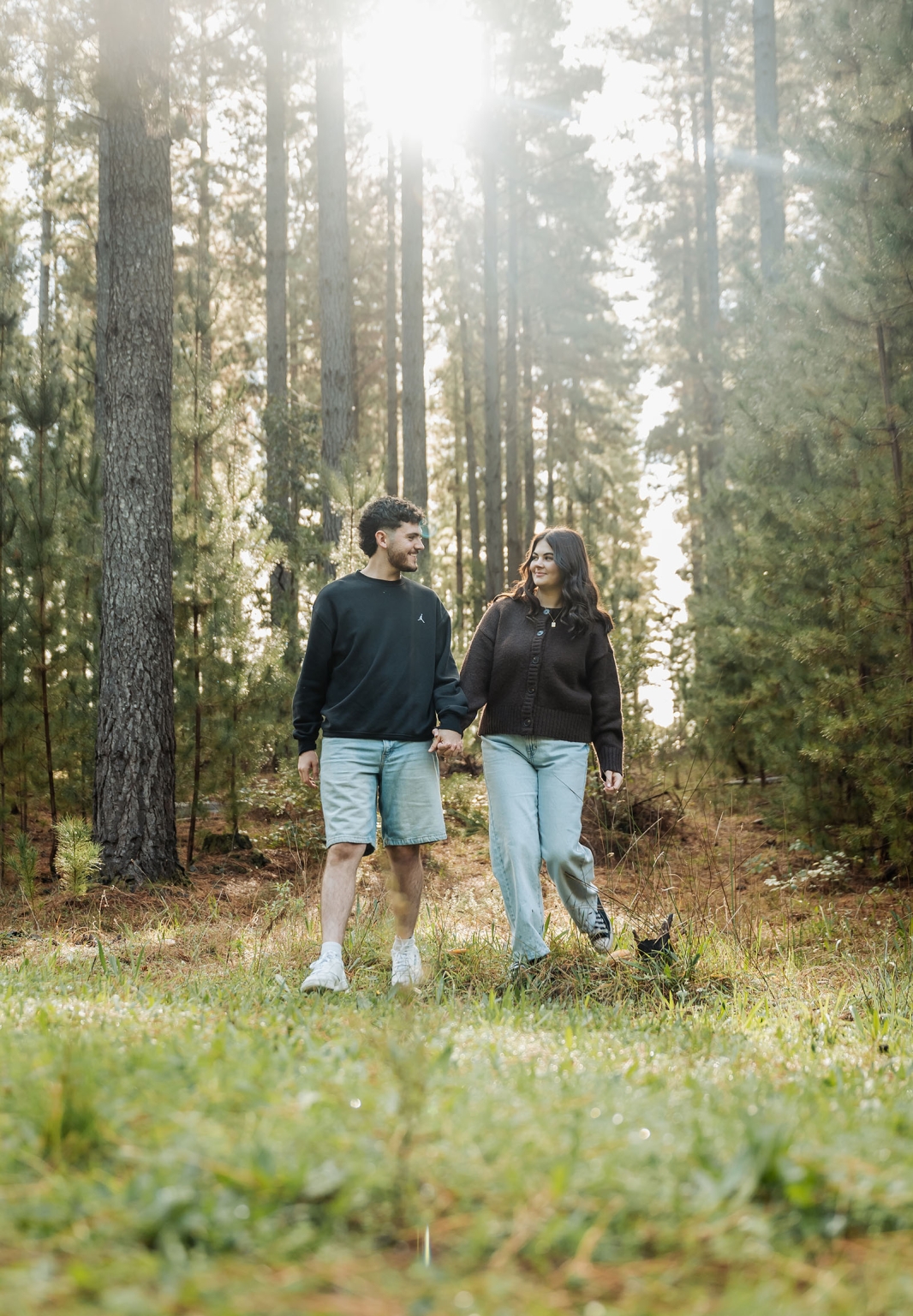 cabn at kuitpo forest proposal - tamsyn & blake 26 A couple enjoys a peaceful walk in a sunlit, lush forest.