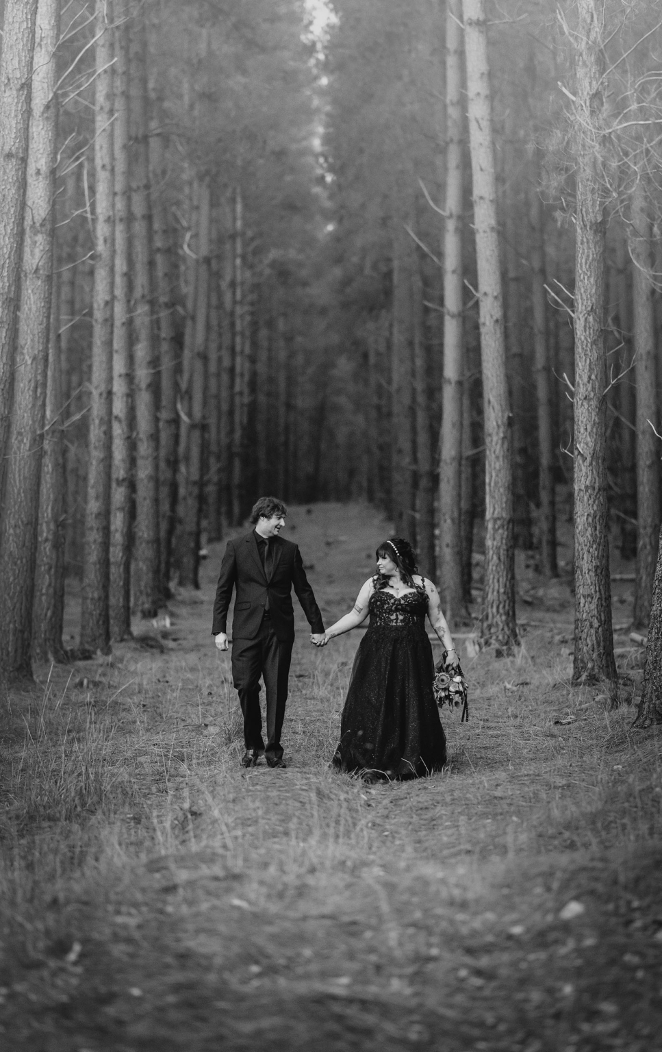 kuitpo forest metal themed wedding – erin & michael 25 Gothic forest wedding portrait of a couple holding hands among towering trees.