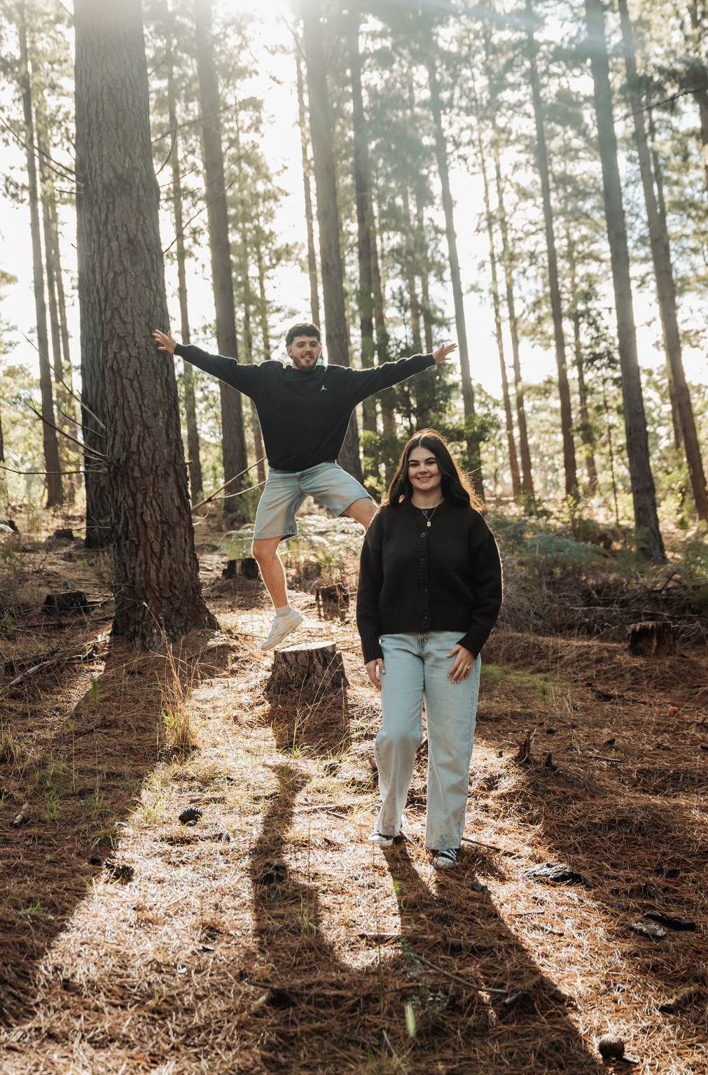 cabn at kuitpo forest proposal - tamsyn & blake 31 Two people enjoy a sunlit forest, blending adventure and tranquility.