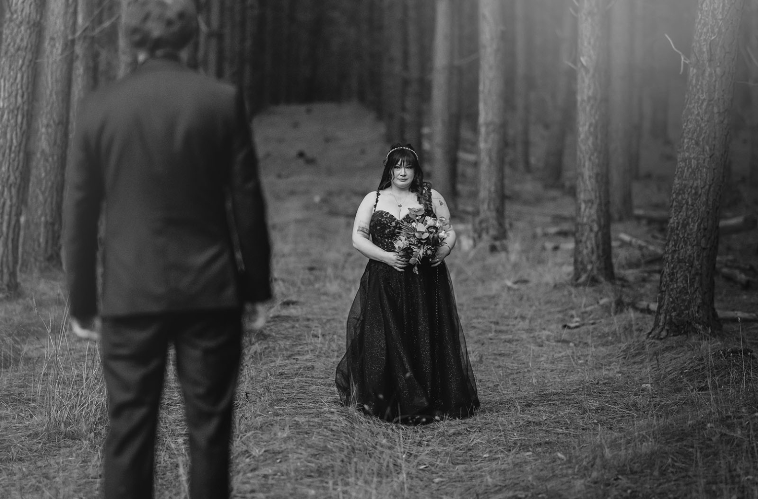 kuitpo forest metal themed wedding – erin & michael 26 Black and white forest wedding portrait with bride holding bouquet and groom in foreground.