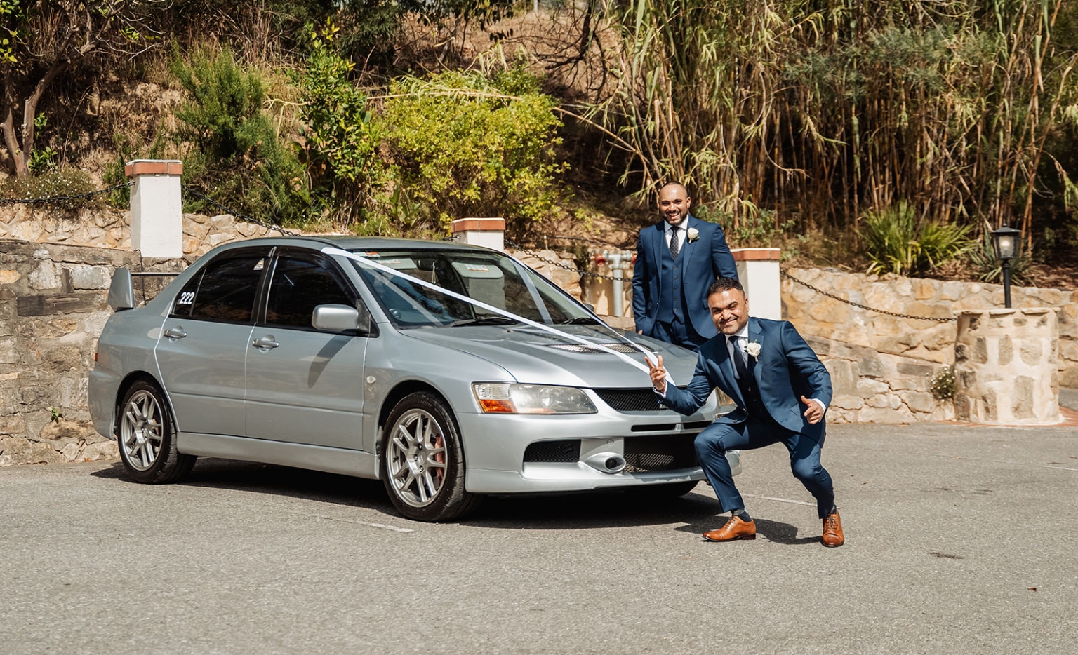 manor wedding in basket range - methmini & aravinda 104 Formal celebration with decorated car and men in suits outdoors.