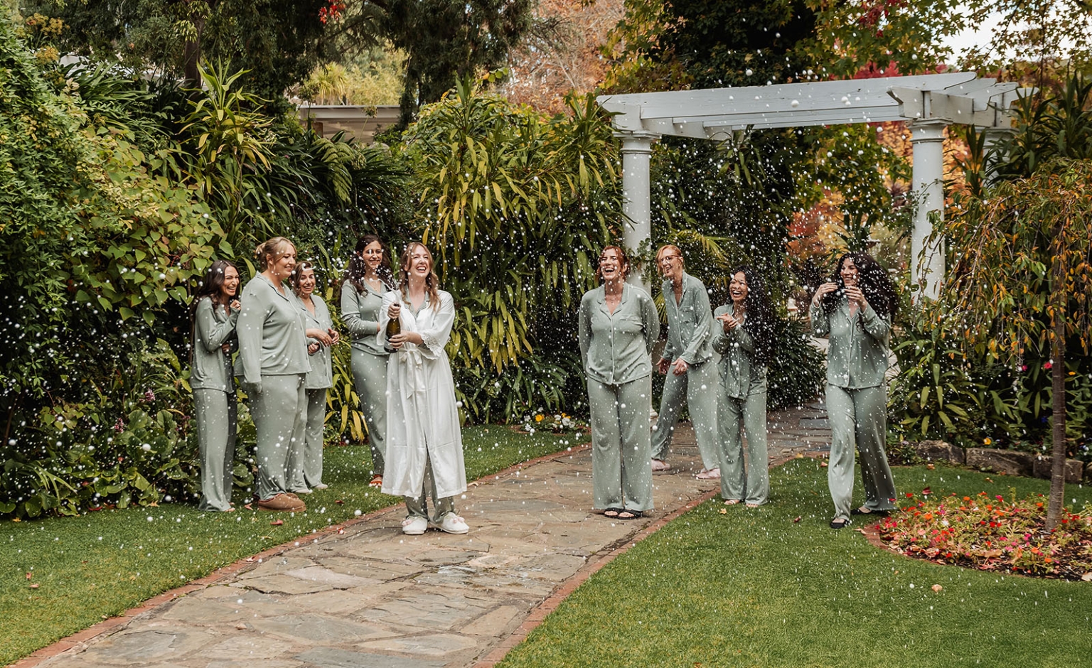 beautiful manor basket range wedding - sophie & theodore 90 Bride and bridesmaids celebrate with champagne in a lush garden setting.