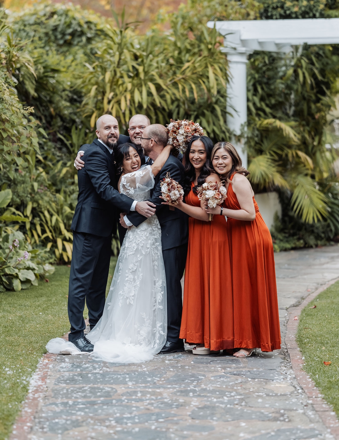 adelaide hills wedding at the manor - jo & dan 39 Joyful garden wedding party with bride, groom, bridesmaids, bouquets, and lush greenery.