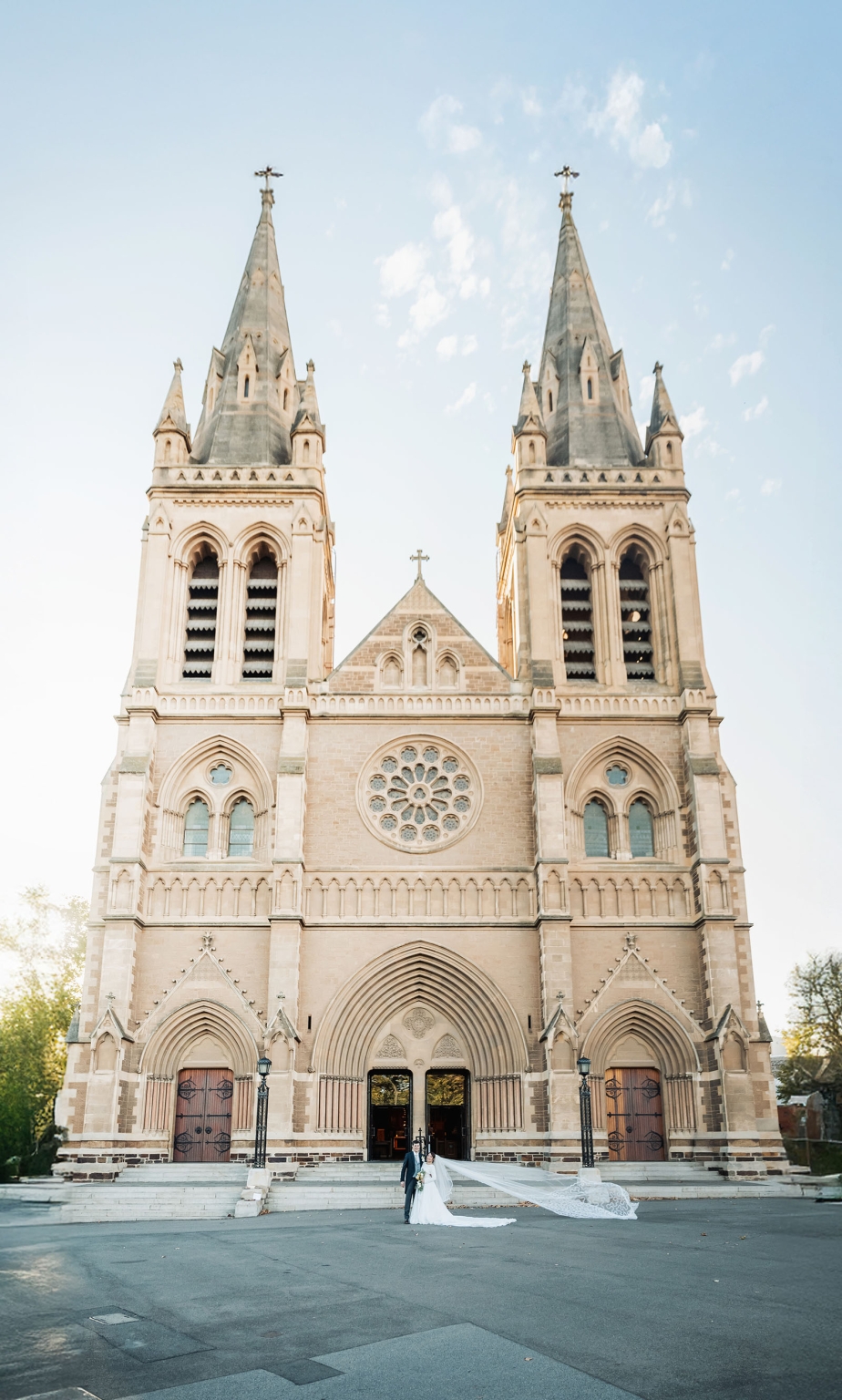 adelaide's st peter's cathedral wedding - irish & nick 36 Bride and groom wedding portrait before grand Gothic cathedral with flowing veil.
