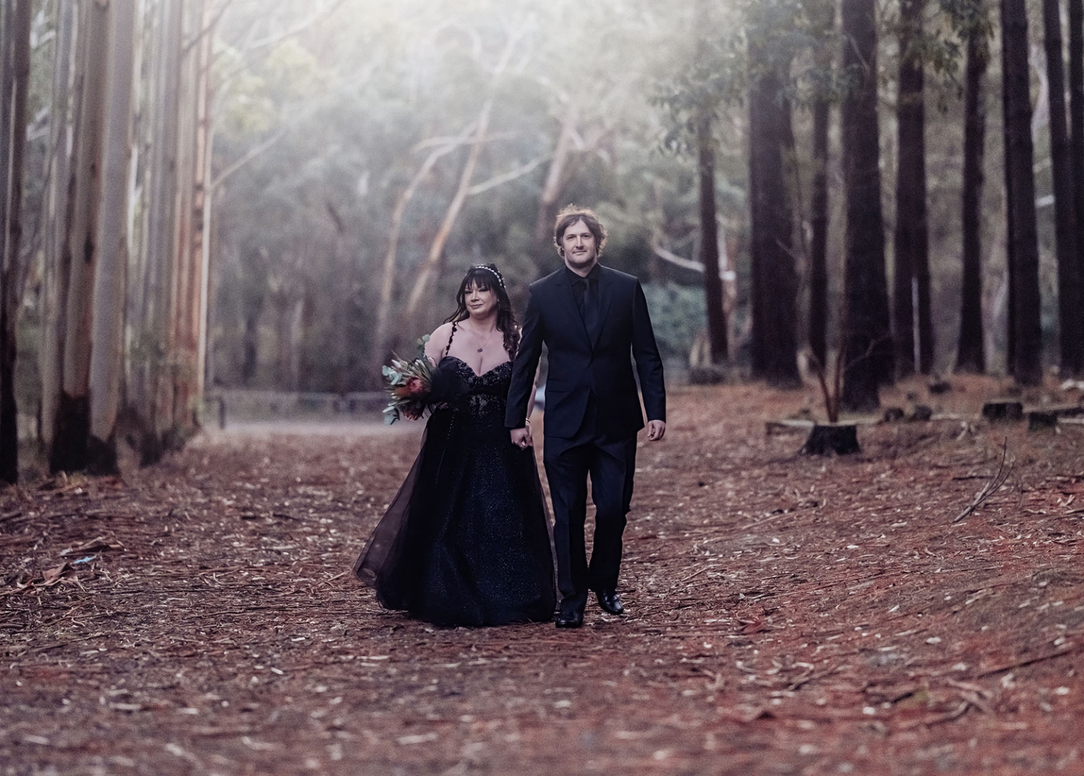 kuitpo forest metal themed wedding – erin & michael 28 Gothic forest wedding couple walking hand in hand in dark romantic woodland.