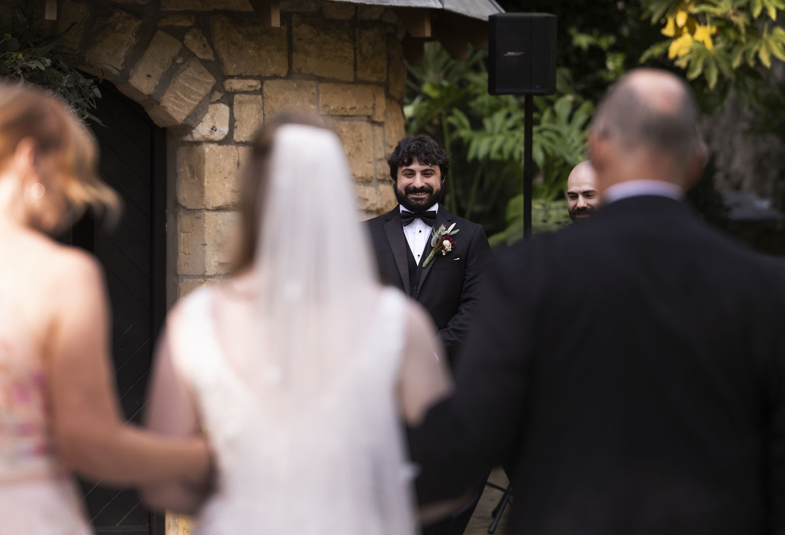 beautiful manor basket range wedding - sophie & theodore 100 Groom smiling joyfully at outdoor wedding ceremony under stone archway.