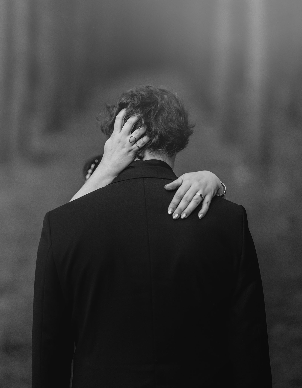 kuitpo forest metal themed wedding – erin & michael 27 Black-and-white portrait of an intimate embrace with hands, rings, and dark suit.