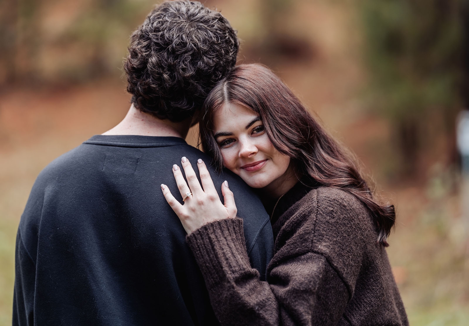 cabn at kuitpo forest proposal - tamsyn & blake 21 Couples intimate outdoor moment with engagement ring in serene autumn setting.