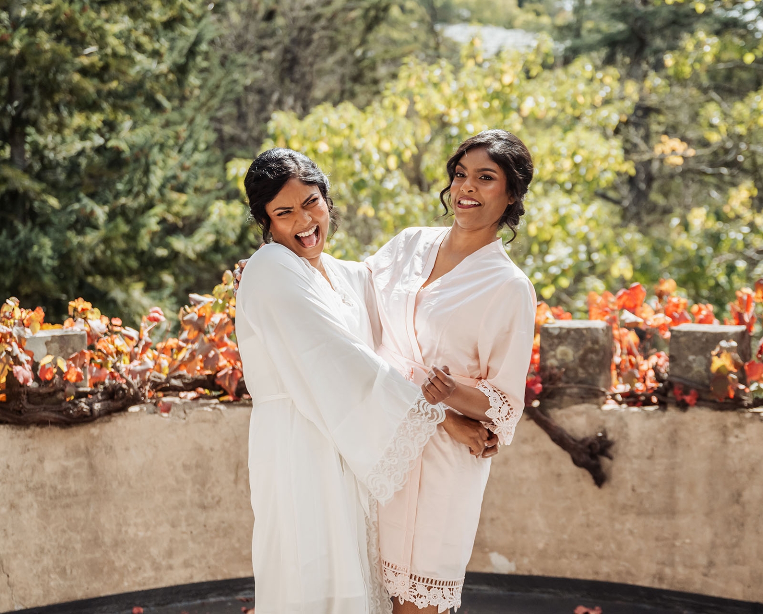 manor wedding in basket range - methmini & aravinda 111 Elegant friends in lace robes, enjoying a sunny moment in lush greenery.