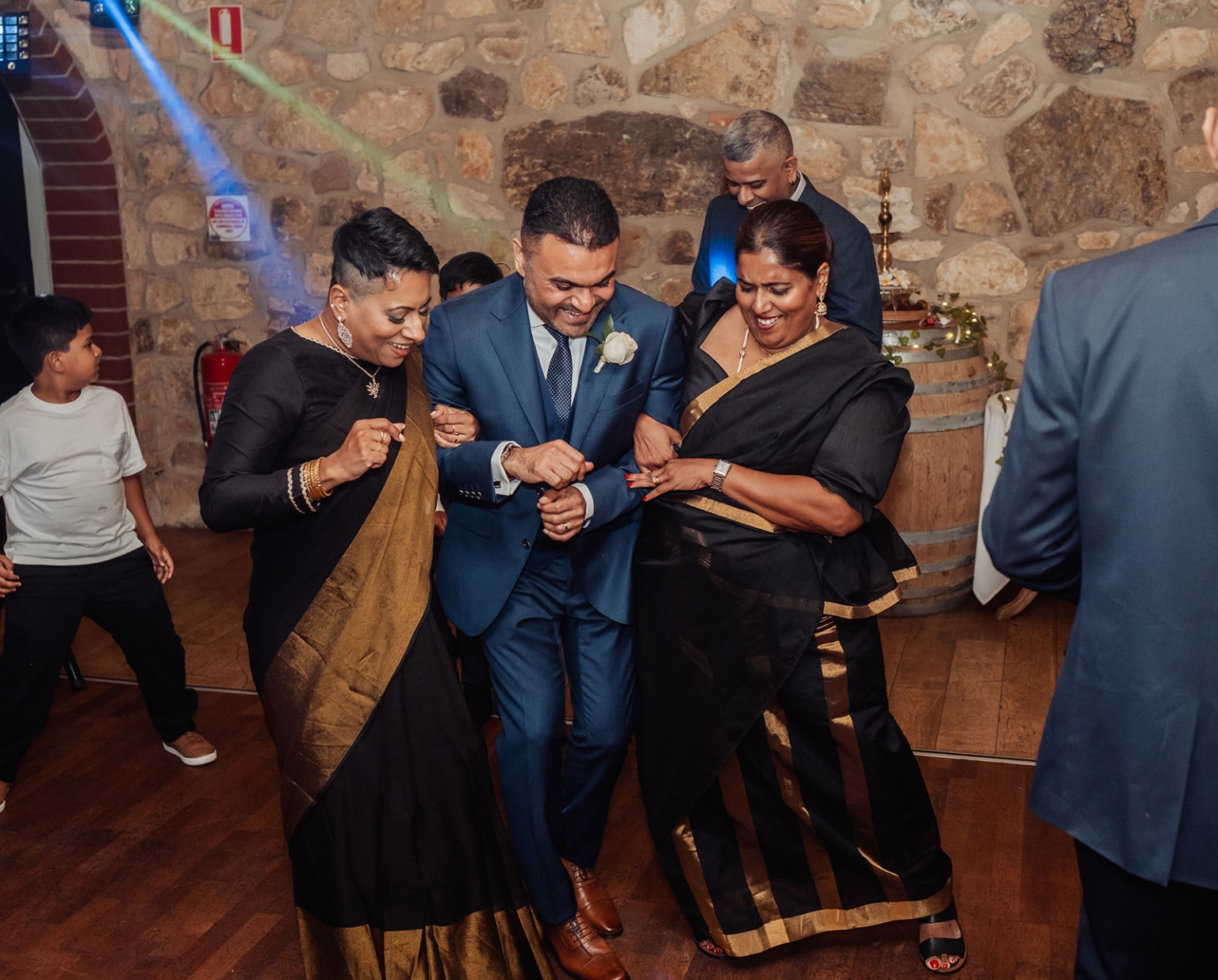 manor wedding in basket range - methmini & aravinda 170 Festive dance: people in elegant attire celebrate joyfully in a rustic setting.