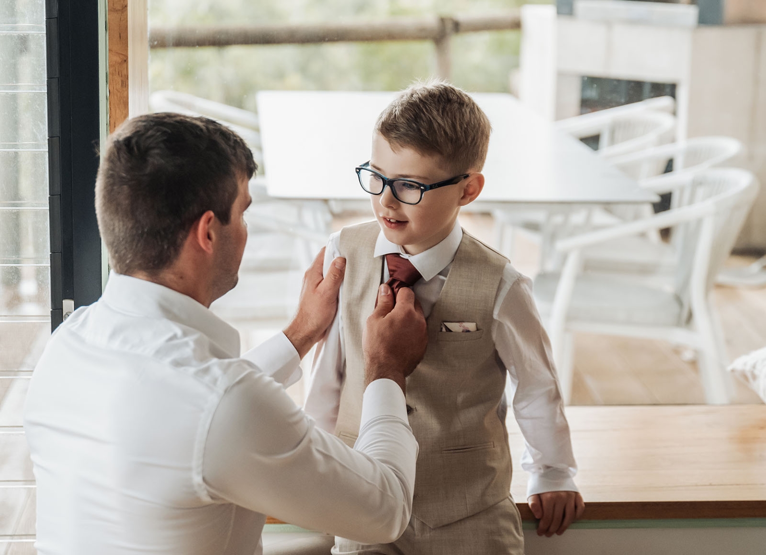 the lane vineyard wedding - caitlyn & craig 68 Father adjusts sons tie in formal attire, highlighting care and bonding moment indoors.