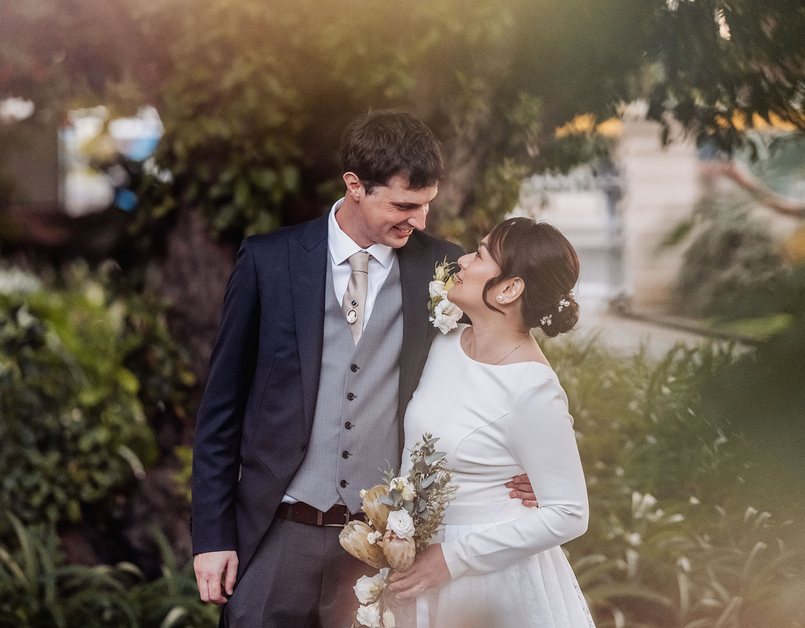 romantic garden wedding portrait of newlyweds Newlywed couple in garden wedding portrait with bouquet and romantic greenery.