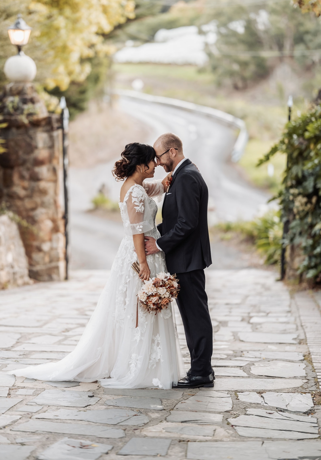 adelaide hills wedding at the manor - jo & dan 47 Newlywed couple in romantic outdoor wedding portrait with lace gown and dark suit.
