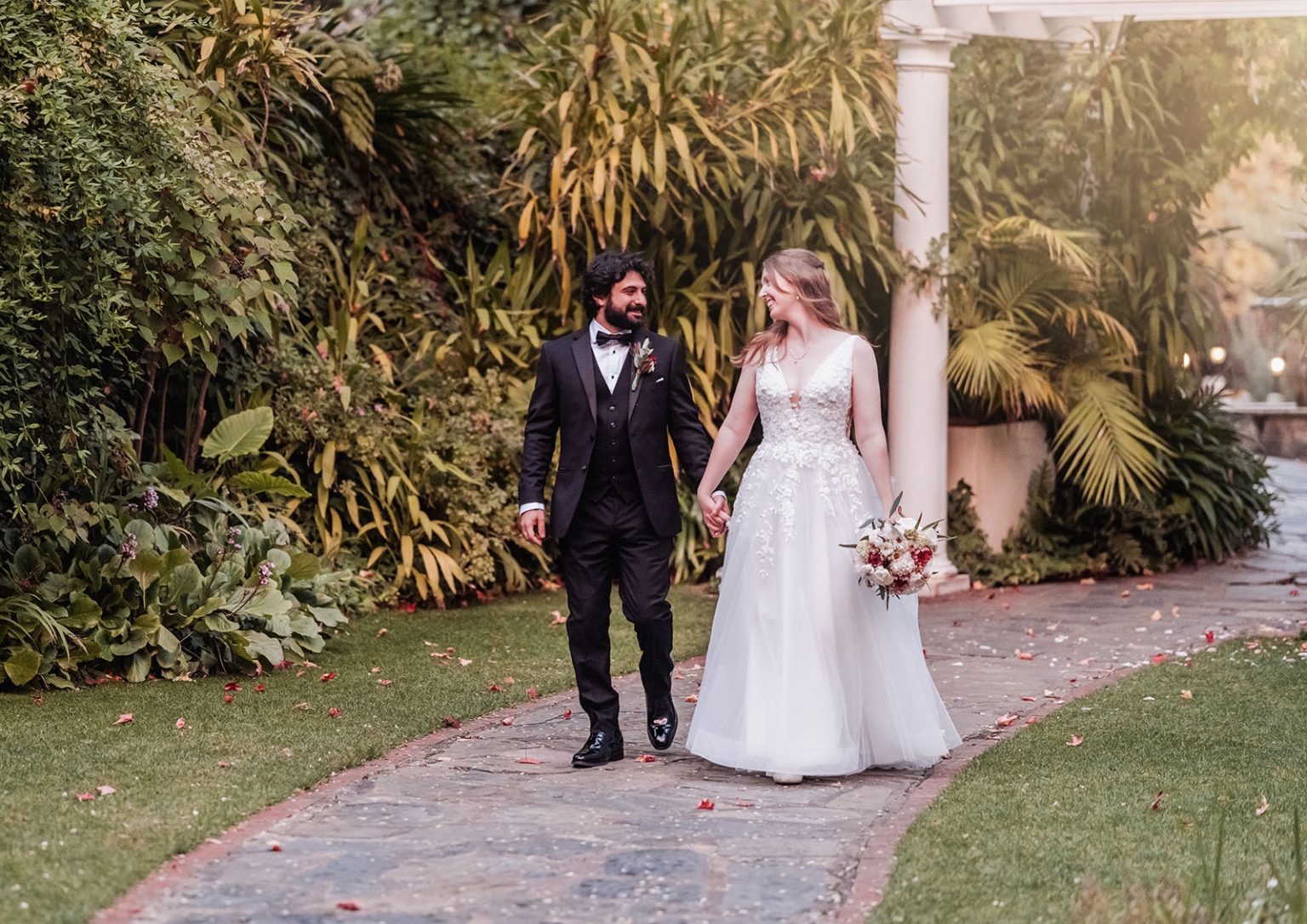 beautiful manor basket range wedding - sophie & theodore 134 Newlywed couple walking in lush garden, elegant attire, autumn setting, romantic atmosphere.
