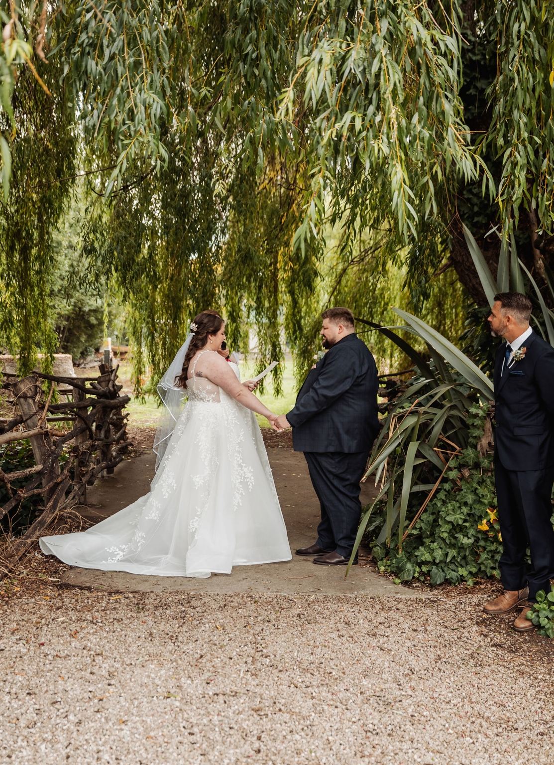 comida wedding - georgia & james 19 Bride and groom under trees during an intimate outdoor wedding ceremony.