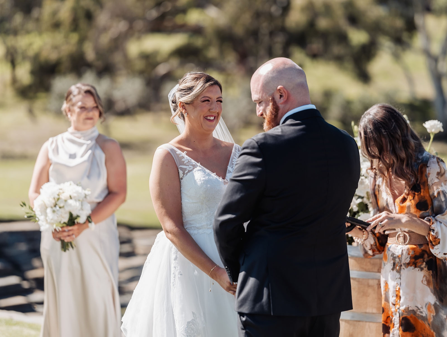 lloyd brothers wedding - dajana & tom 12 Joyful outdoor wedding ceremony with couple exchanging vows in scenic garden setting.