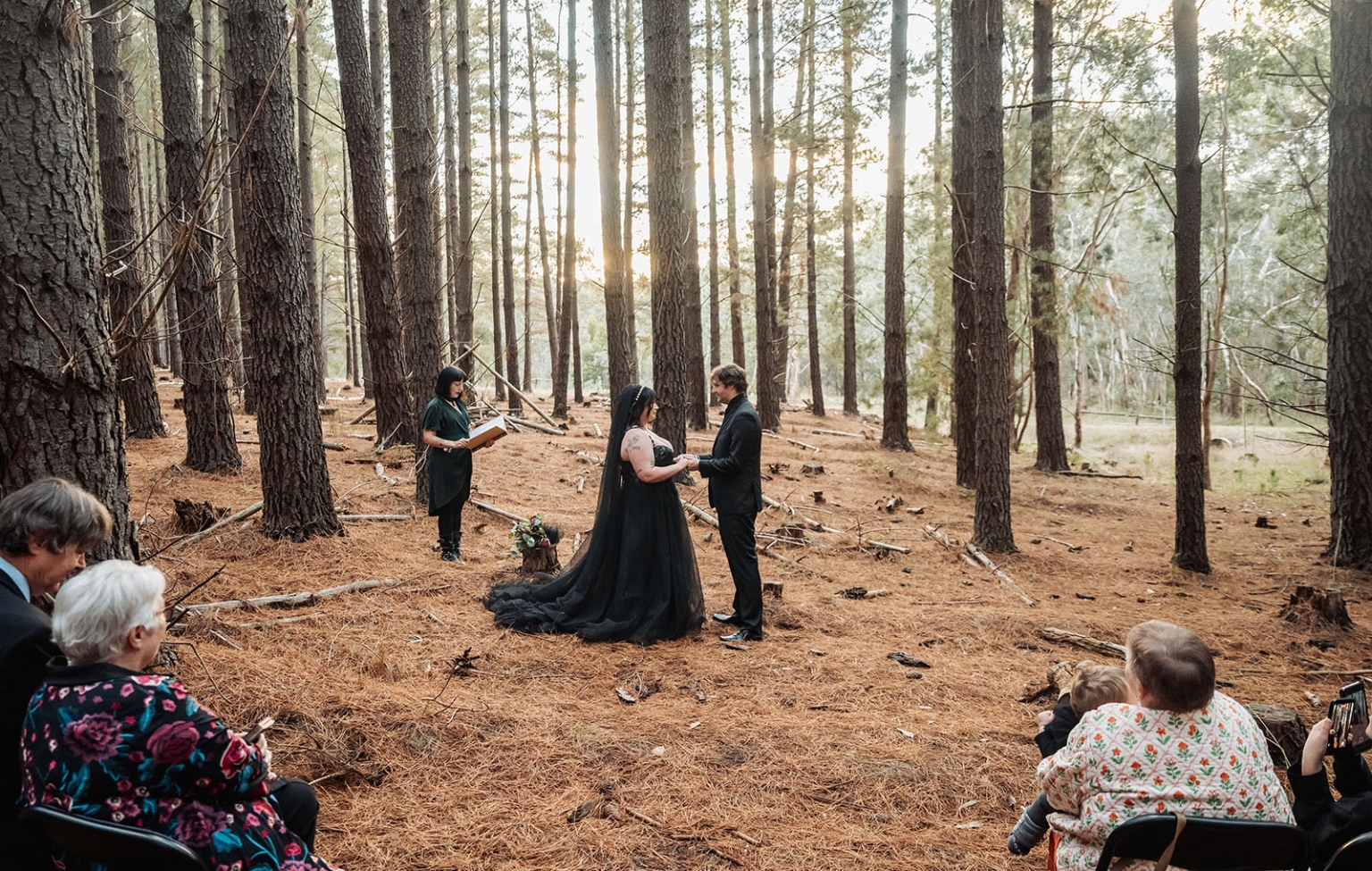 kuitpo forest metal themed wedding – erin & michael 12 Intimate pine forest wedding ceremony with bride in black gown and woodland guests.
