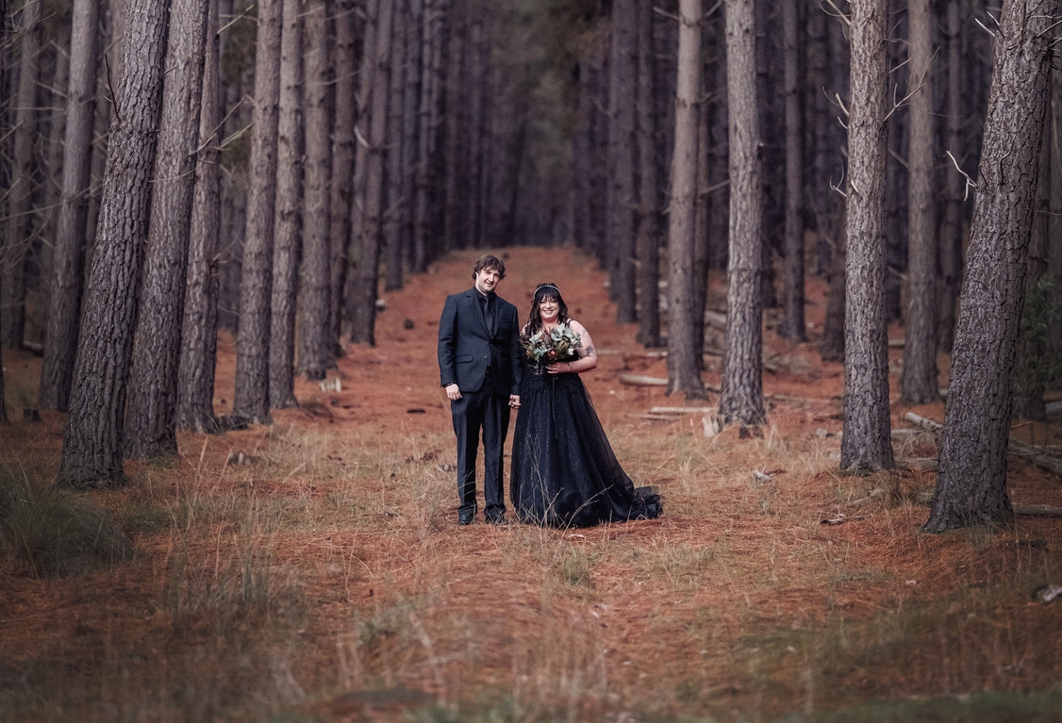 kuitpo forest metal themed wedding – erin & michael 23 Gothic wedding portrait of couple in black attire in a pine forest.